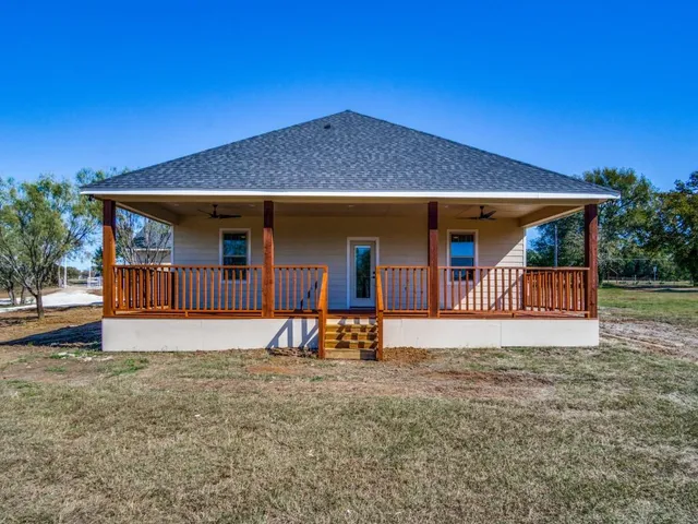 a view of a house with backyard and porch