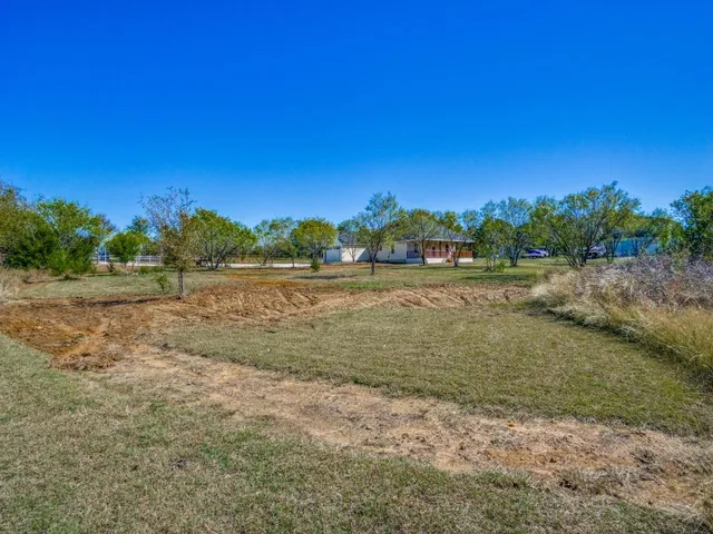 a view of a field with trees in background