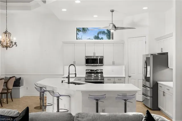 a kitchen with a dining table chairs and a refrigerator
