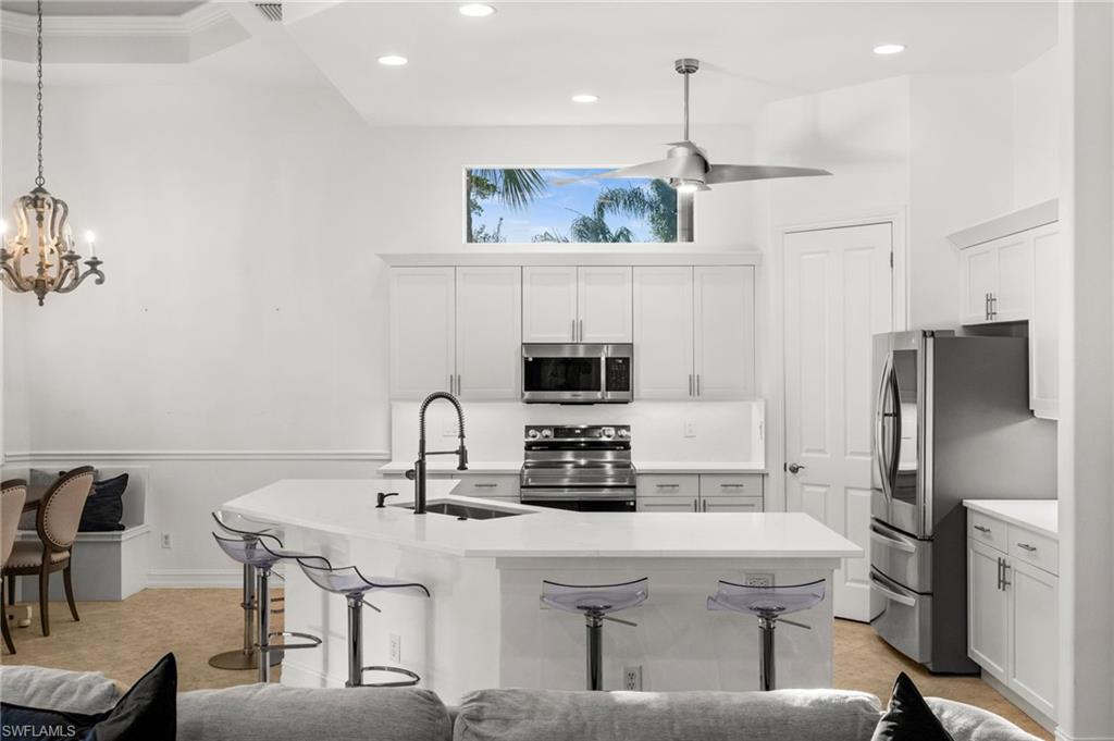 12553 Grandezza Circle Estero, FL 33928 - Photo 11 of 46 a kitchen with a dining table chairs and a refrigerator