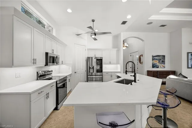 a kitchen with sink a stove and chairs