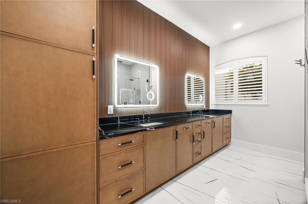 12553 Grandezza Circle Estero, FL 33928 - Photo 25 of 46 a bathroom with a granite countertop sink and a mirror
