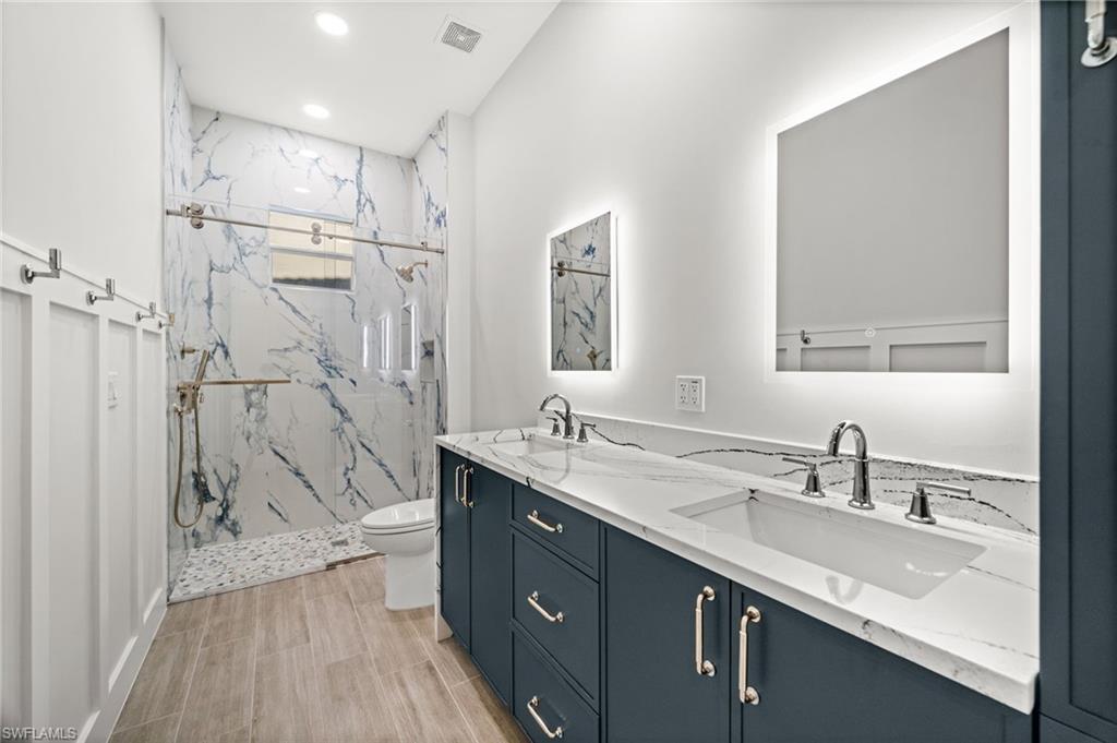 12553 Grandezza Circle Estero, FL 33928 - Photo 30 of 46 a bathroom with a granite countertop sink mirror and a shower