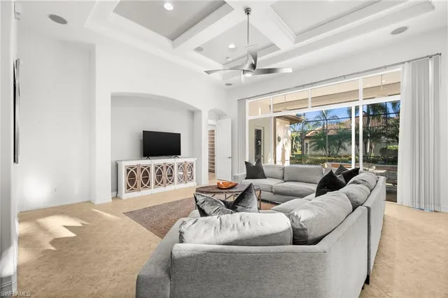 a living room with furniture a flat screen tv and a large window