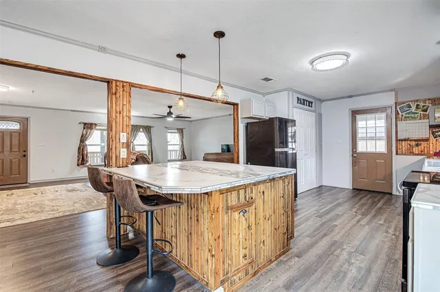 a kitchen with stainless steel appliances kitchen island granite countertop a refrigerator stove microwave and cabinets