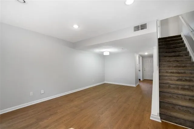 a view of an empty room with wooden floor