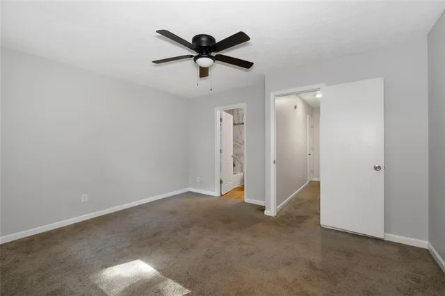 an empty room with closet and a chandelier fan