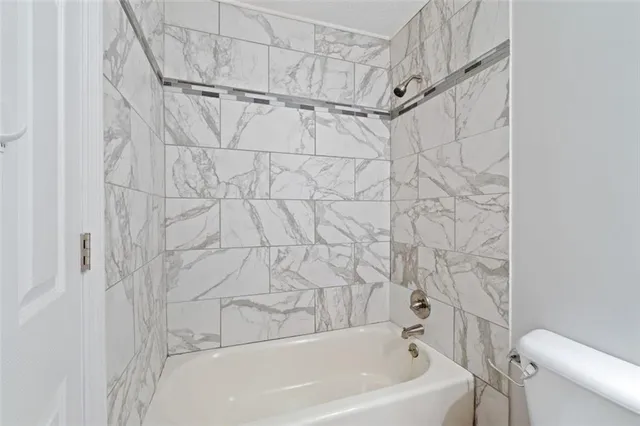 a bathroom with a white bath tub and a shower
