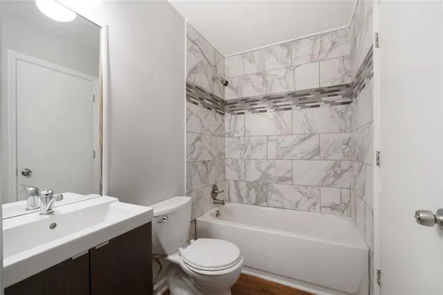a bathroom with a bathtub shower sink vanity and toilet