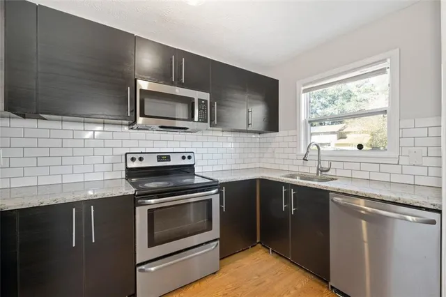 a kitchen with granite countertop cabinets stainless steel appliances and window