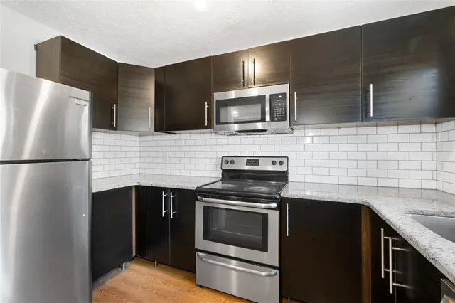 a kitchen with stainless steel appliances wooden cabinets stove and microwave