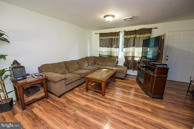 31403 Melson Road Delmar, MD 21875 - Photo 3 of 38 a living room with furniture a flat screen tv and a floor to ceiling window