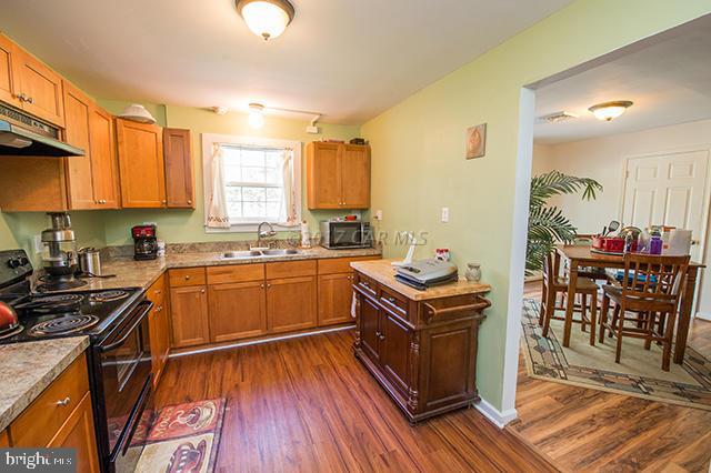 31403 Melson Road Delmar, MD 21875 - Photo 8 of 38 a kitchen with stainless steel appliances granite countertop a stove a sink dishwasher and a refrigerator with wooden floor