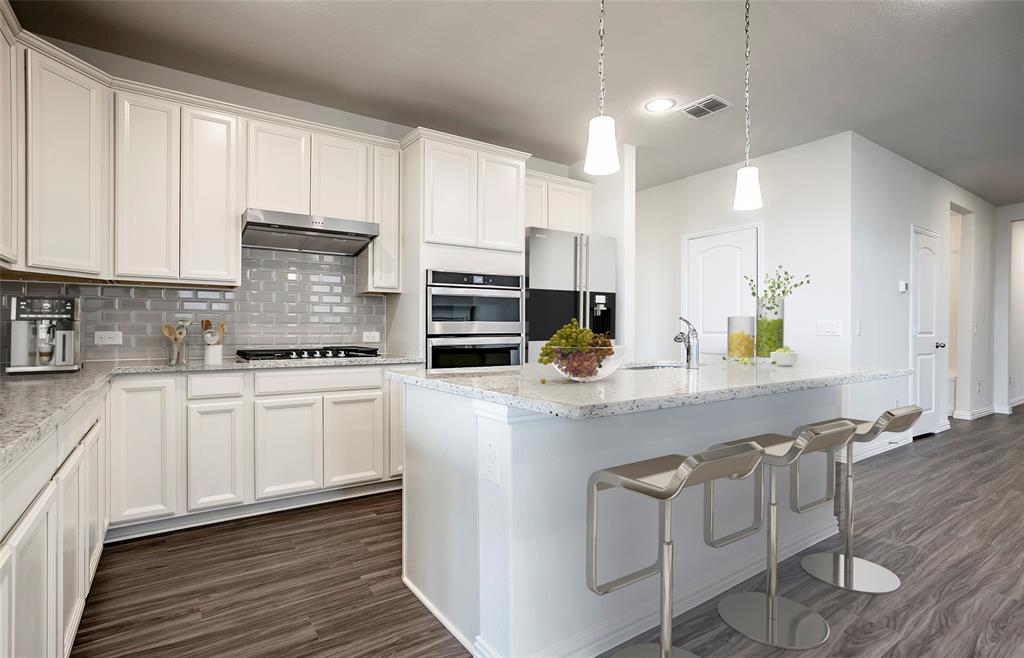457 Avian Way Godley, TX 76044 - Photo 4 of 9 a kitchen with stainless steel appliances white cabinets a sink and a stove