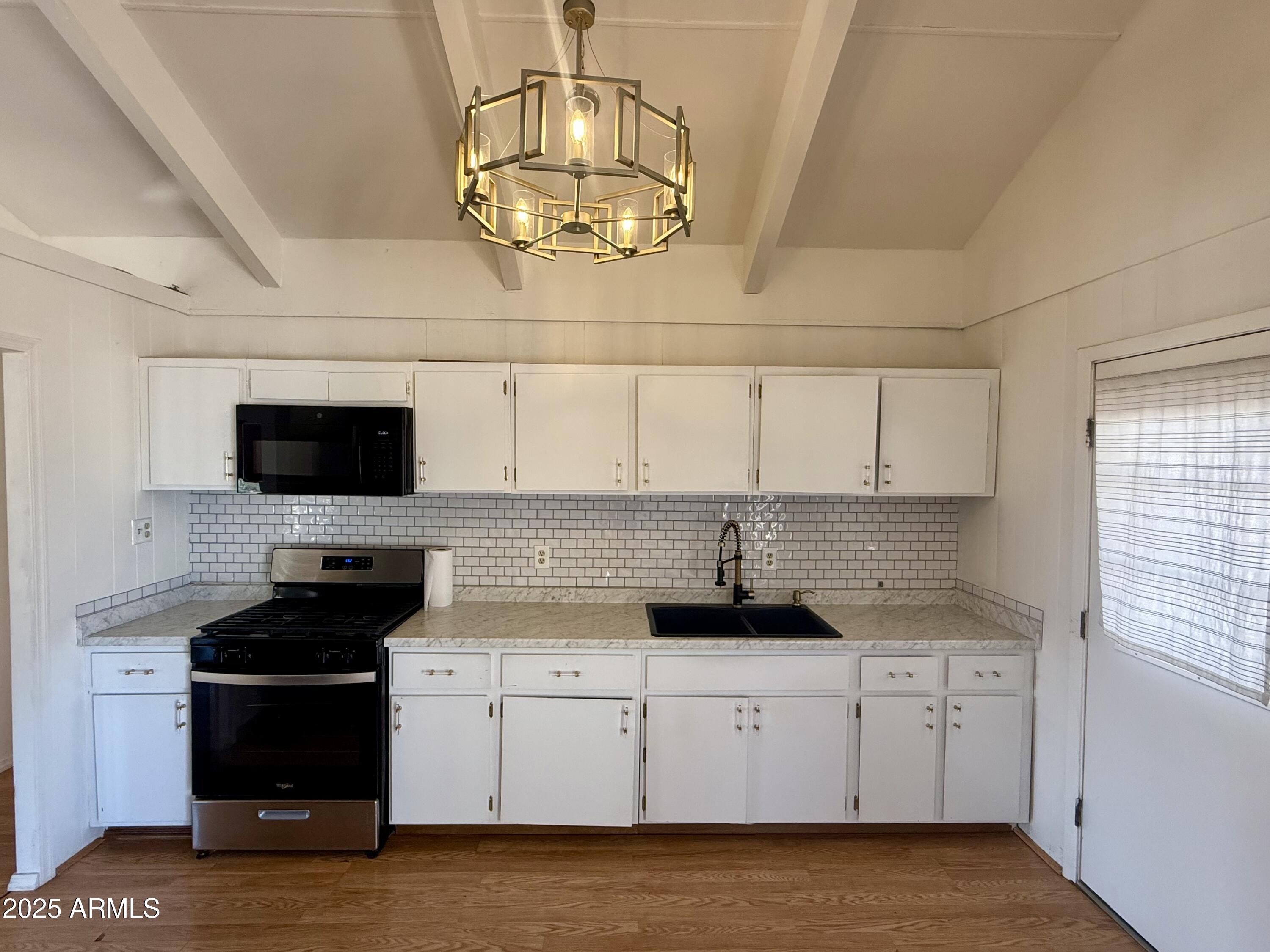 150 West North Street Ajo, AZ 85321 - Photo 11 of 37 a kitchen with stainless steel appliances granite countertop a stove a sink and a white cabinets
