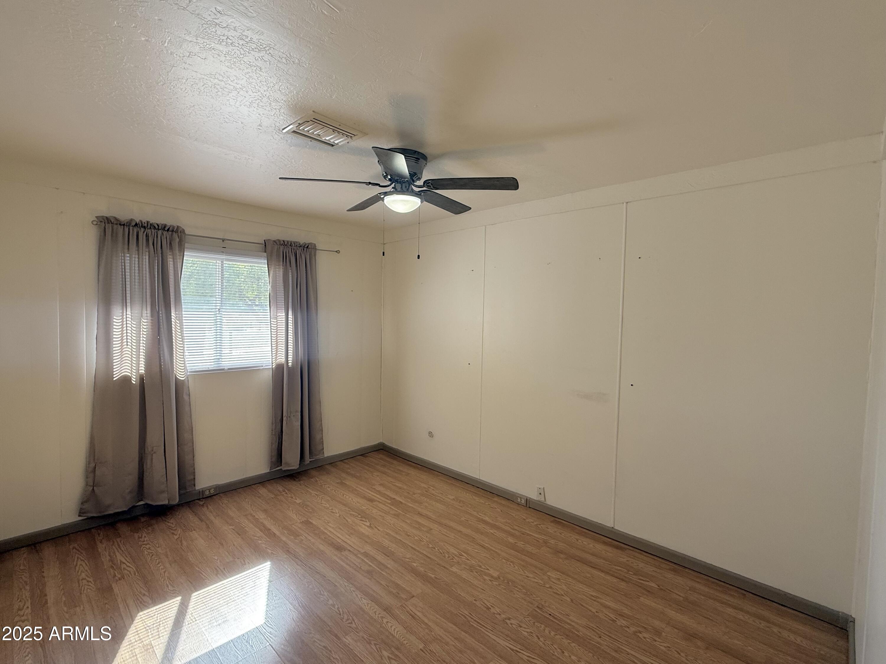 150 West North Street Ajo, AZ 85321 - Photo 18 of 37 an empty room with wooden floor fan and windows