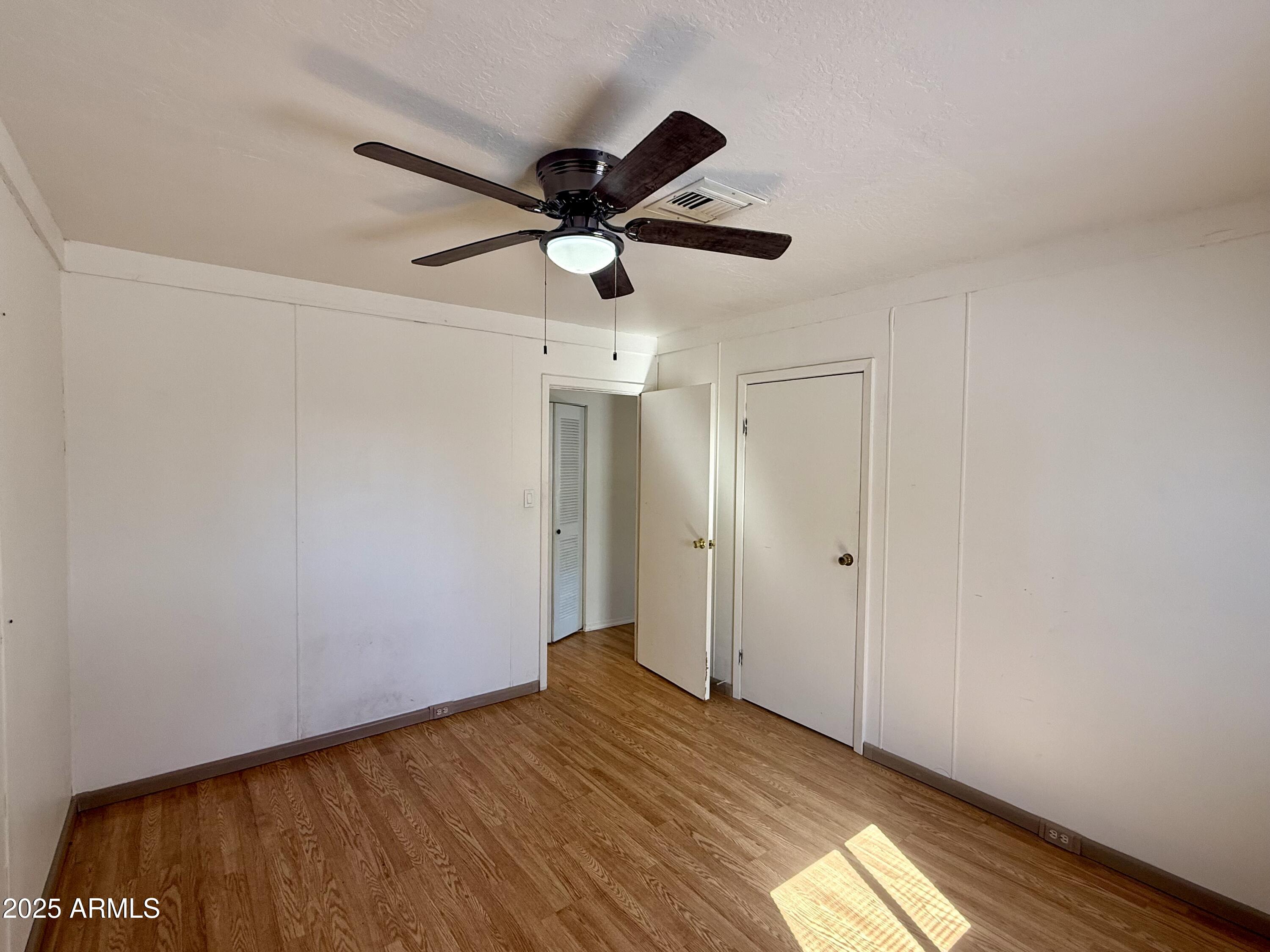 150 West North Street Ajo, AZ 85321 - Photo 19 of 37 a view of a big room with wooden floor closet and ceiling fan