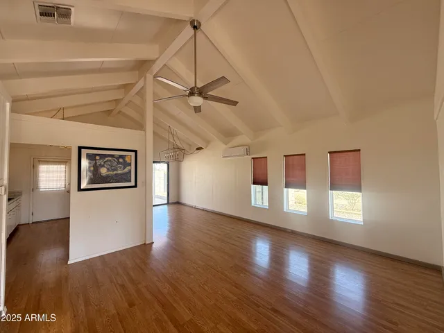 a view of a livingroom with a flat screen tv and kitchen view