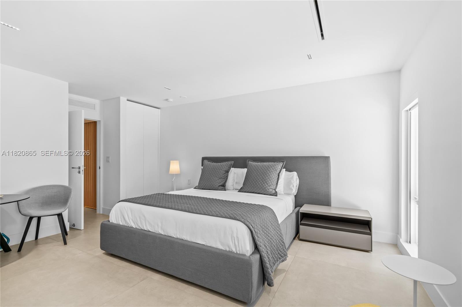 9033 Emerson Avenue Surfside, FL 33154 - Photo 13 of 40 a bedroom with a bed and a lamp