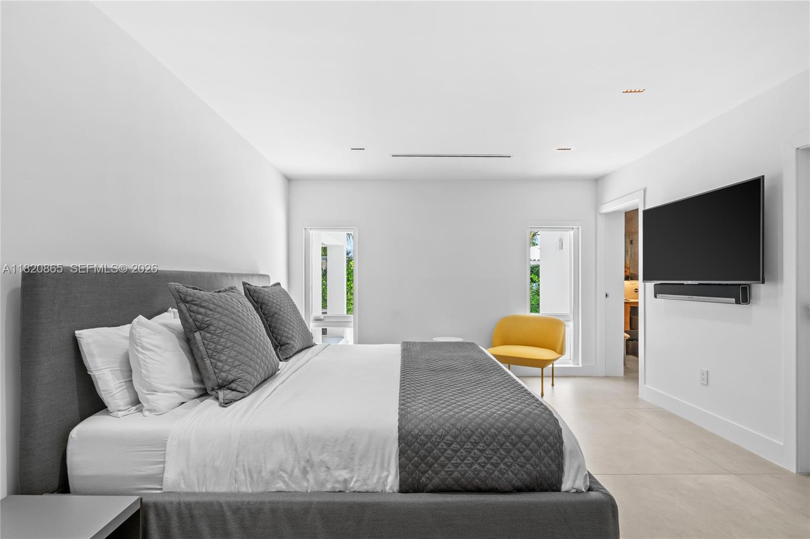 9033 Emerson Avenue Surfside, FL 33154 - Photo 14 of 40 a bedroom with a bed and a flat screen tv