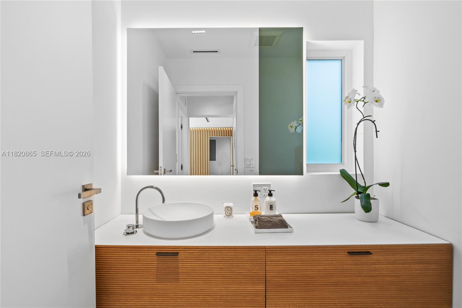 9033 Emerson Avenue Surfside, FL 33154 - Photo 22 of 40 a bathroom with a sink and a mirror