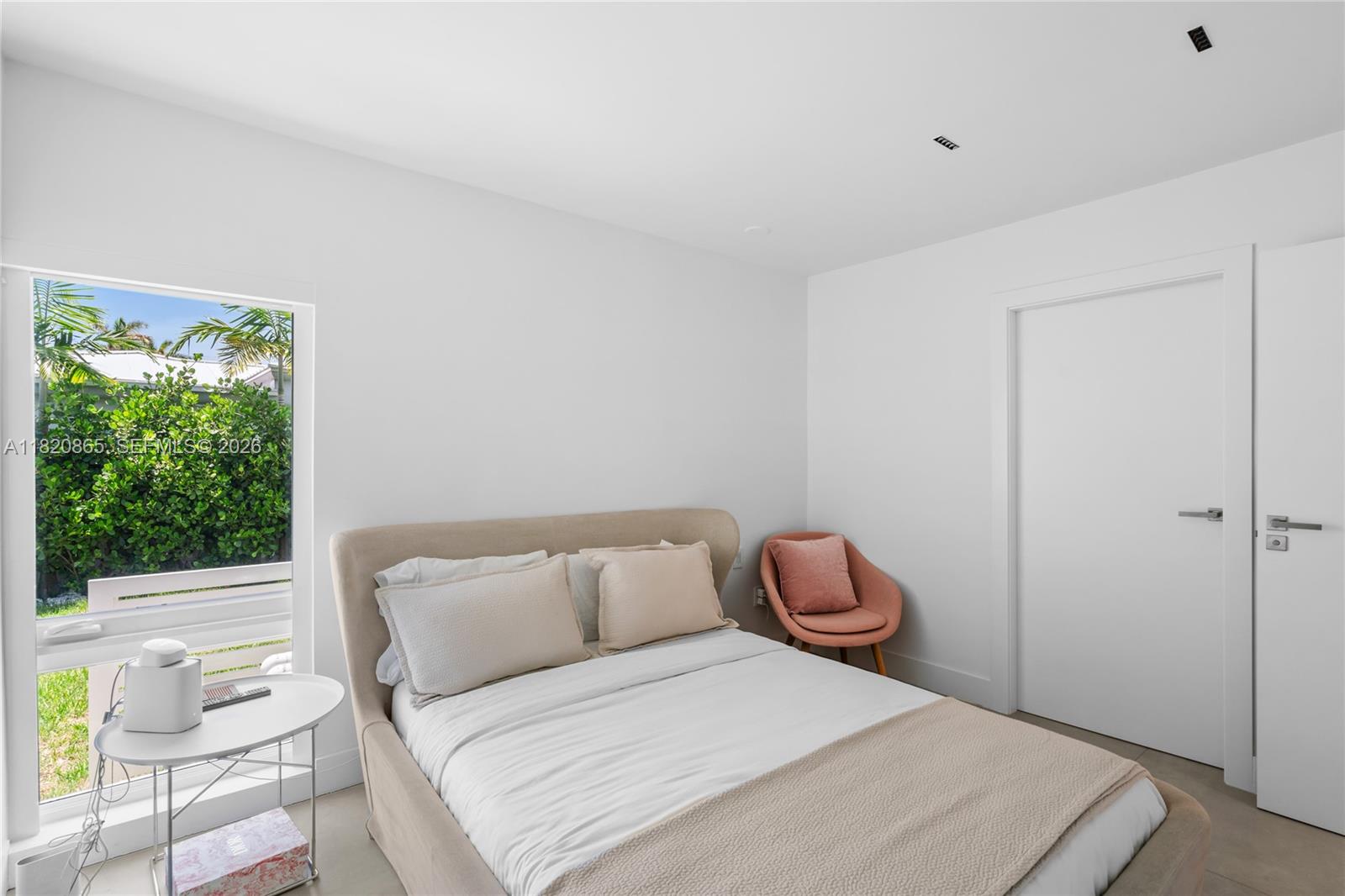 9033 Emerson Avenue Surfside, FL 33154 - Photo 28 of 40 a bedroom with a bed and a chair