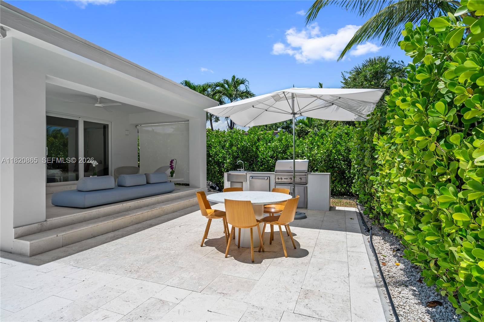 9033 Emerson Avenue Surfside, FL 33154 - Photo 32 of 40 a view of a patio with a table and chairs under an umbrella