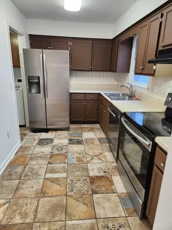 a kitchen with stainless steel appliances granite countertop a refrigerator and a sink