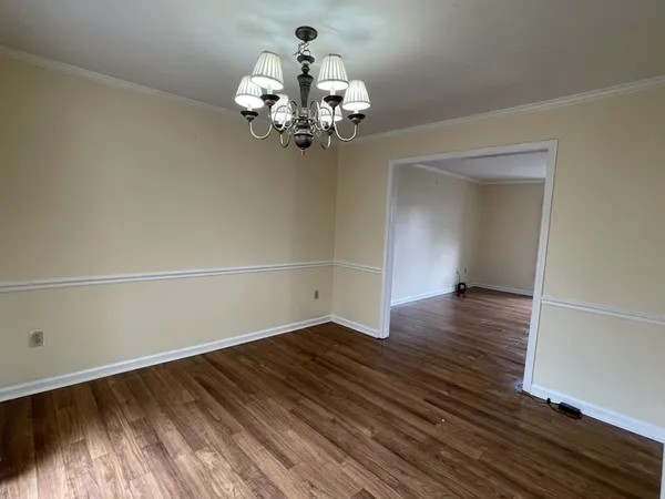 a view of a room with wooden floor and chandelier