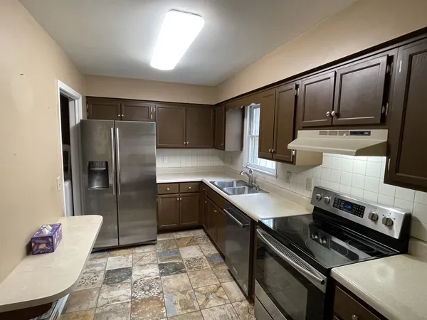 a kitchen with stainless steel appliances granite countertop a sink stove and refrigerator