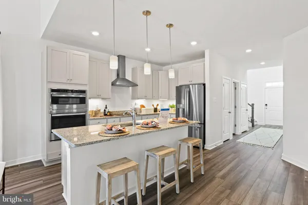 a kitchen with stainless steel appliances granite countertop a sink refrigerator and cabinets