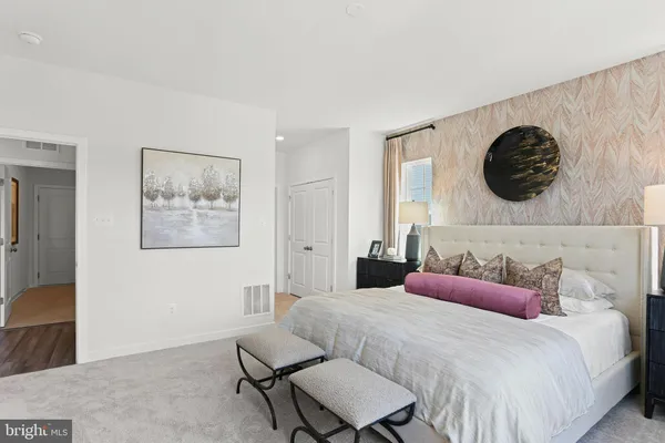 a bedroom with a bed and a painting on the wall