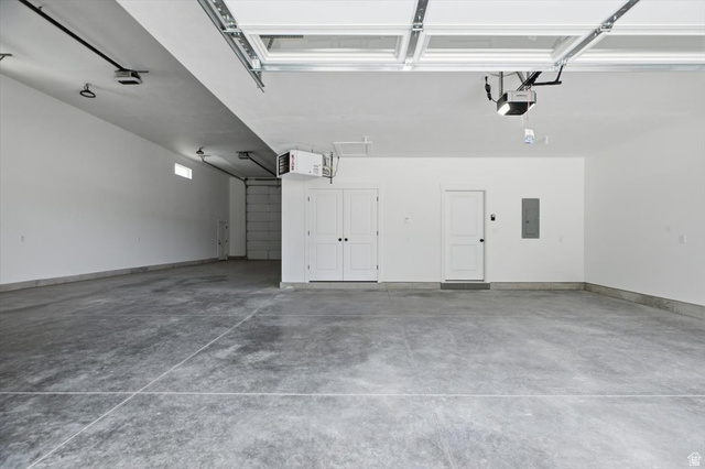 164 North 400 East Preston, ID 83263 - Photo 17 of 21 Spacious garage featuring a concrete floor, two white entry doors, and an overhead garage door with opener