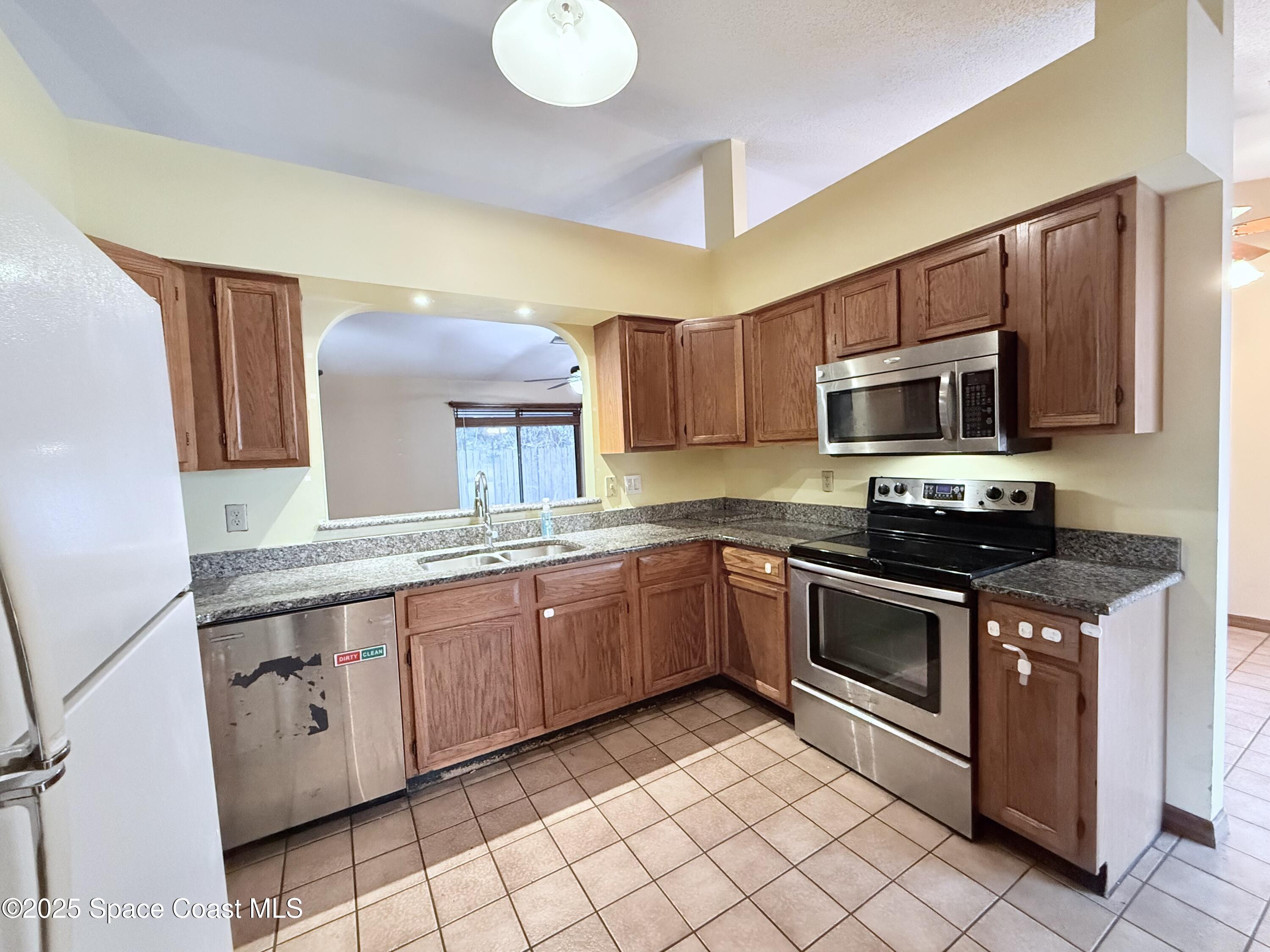 6180 Balboa Street Cocoa, FL 32927 - Photo 15 of 44 a kitchen with stainless steel appliances granite countertop a sink and a stove