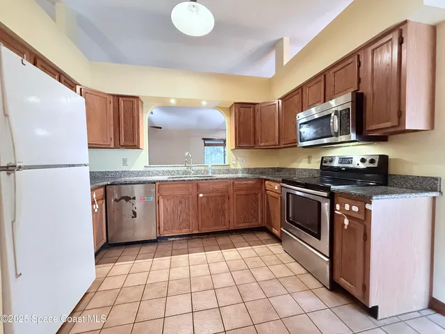 a kitchen with a sink a stove top oven and cabinets