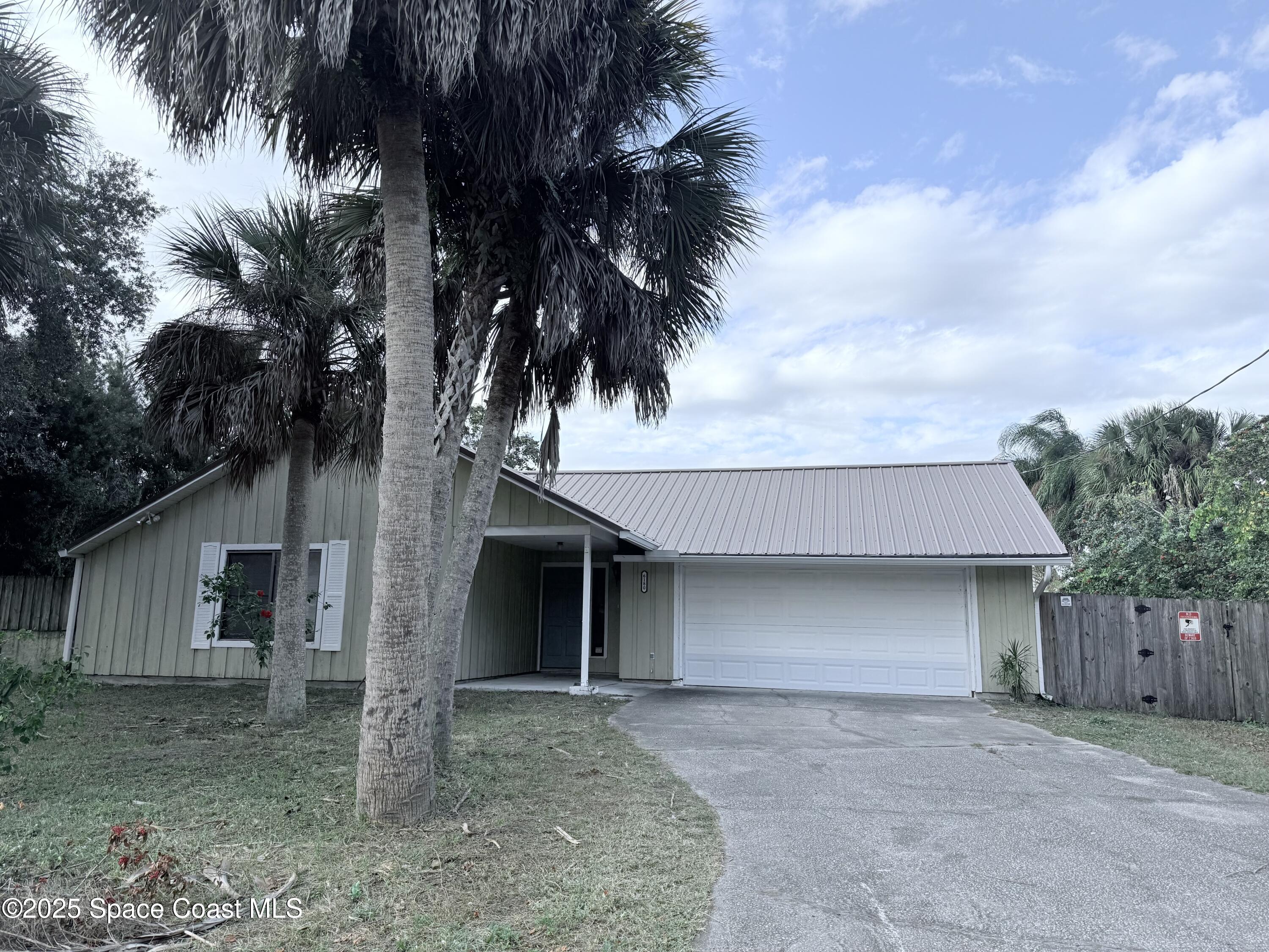 6180 Balboa Street Cocoa, FL 32927 - Photo 2 of 44 a front view of a house with a yard and garage