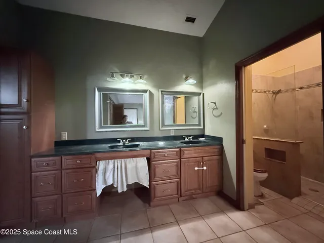 a large bathroom with a double vanity sink a mirror and a bathtub