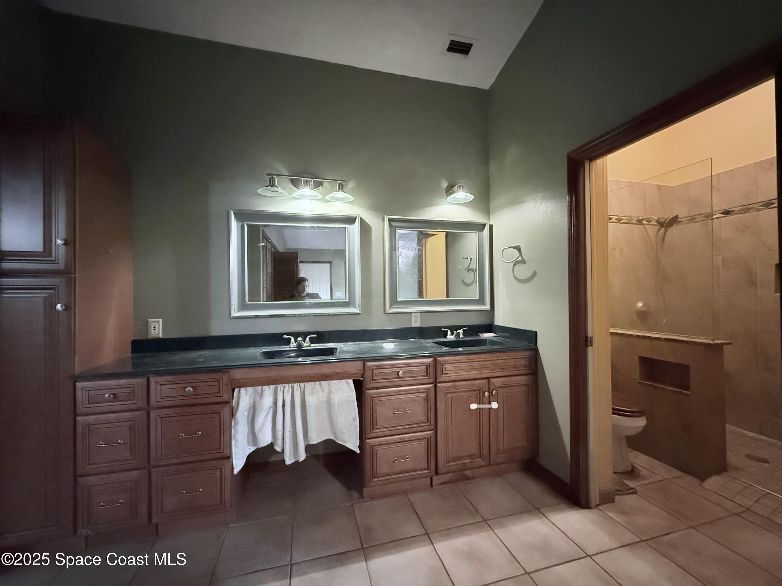 6180 Balboa Street Cocoa, FL 32927 - Photo 22 of 44 a large bathroom with a double vanity sink a mirror and a bathtub