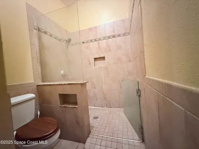 a bathroom with a toilet and a shower