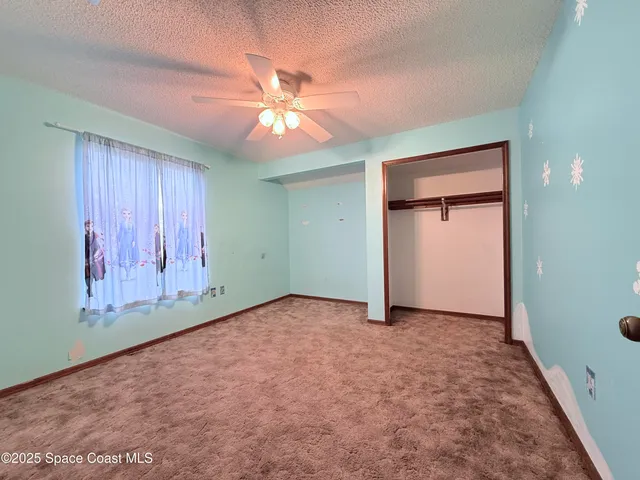 an empty room with closet and fan
