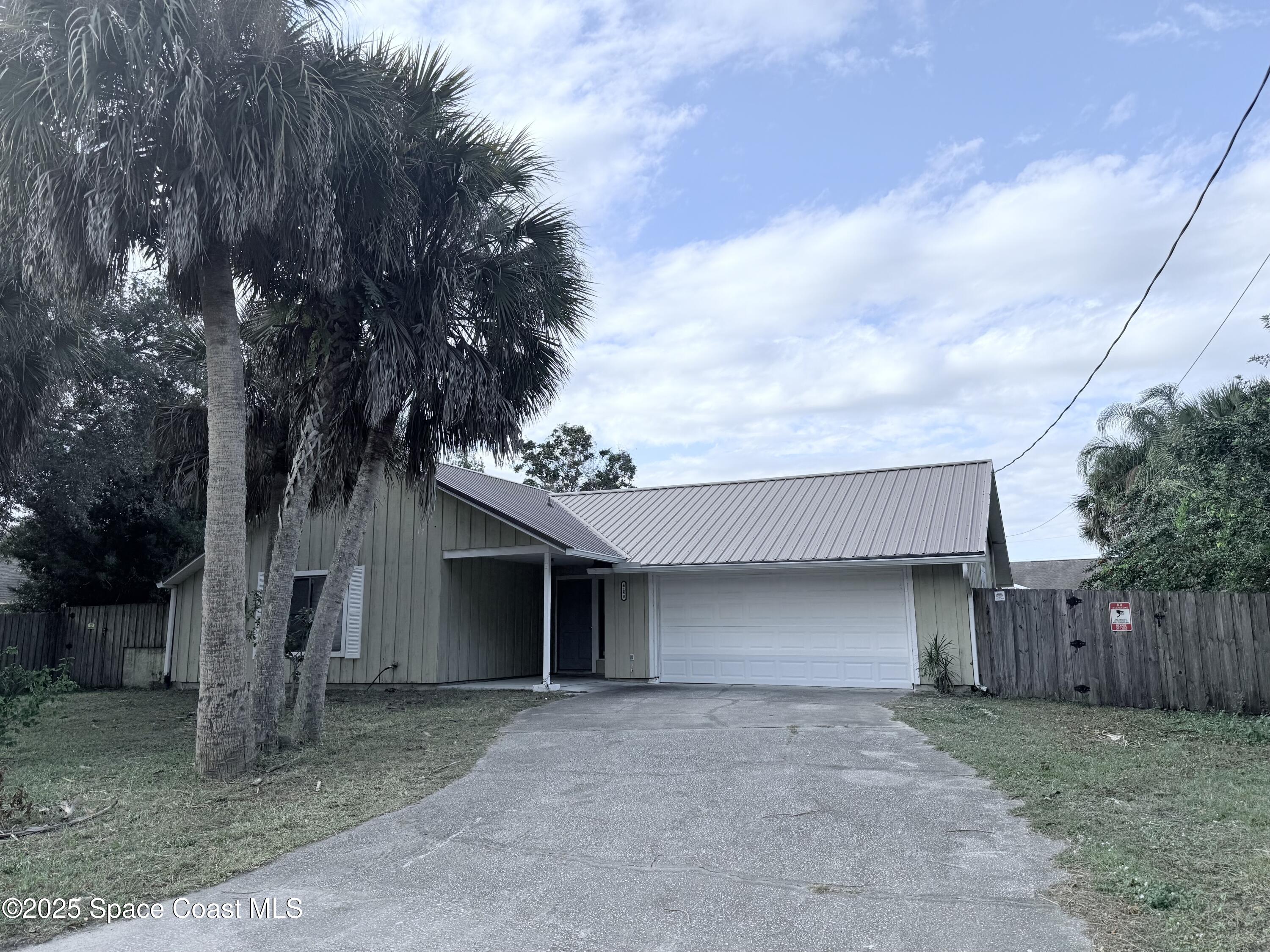 6180 Balboa Street Cocoa, FL 32927 - Photo 3 of 44 a view of a house with a yard and garage