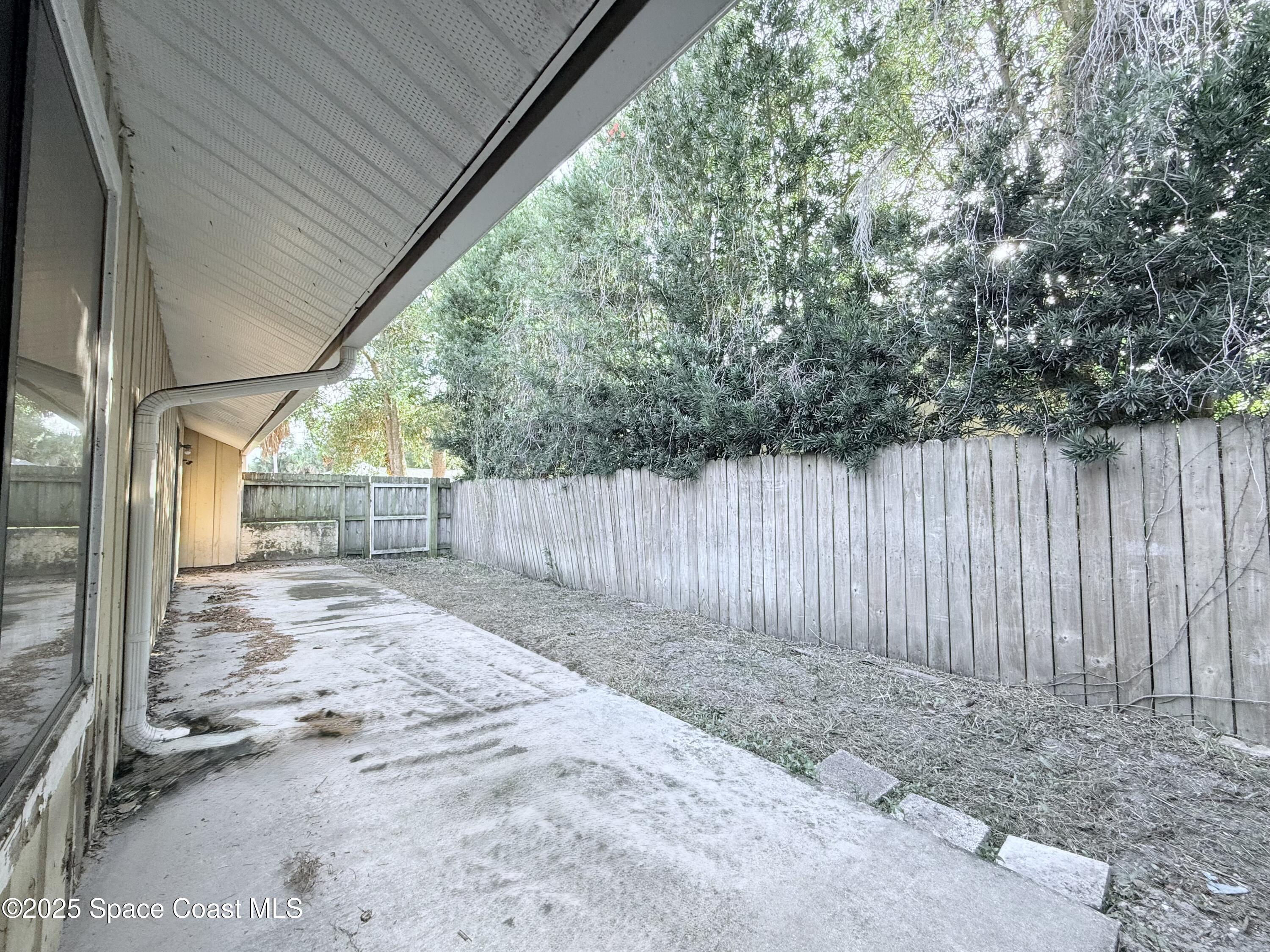 6180 Balboa Street Cocoa, FL 32927 - Photo 32 of 44 a view of a backyard with wooden fence and large trees