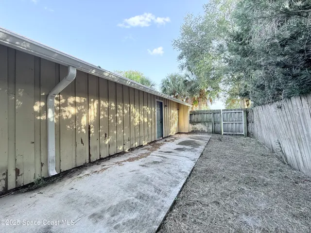 a view of a back yard with wooden fence