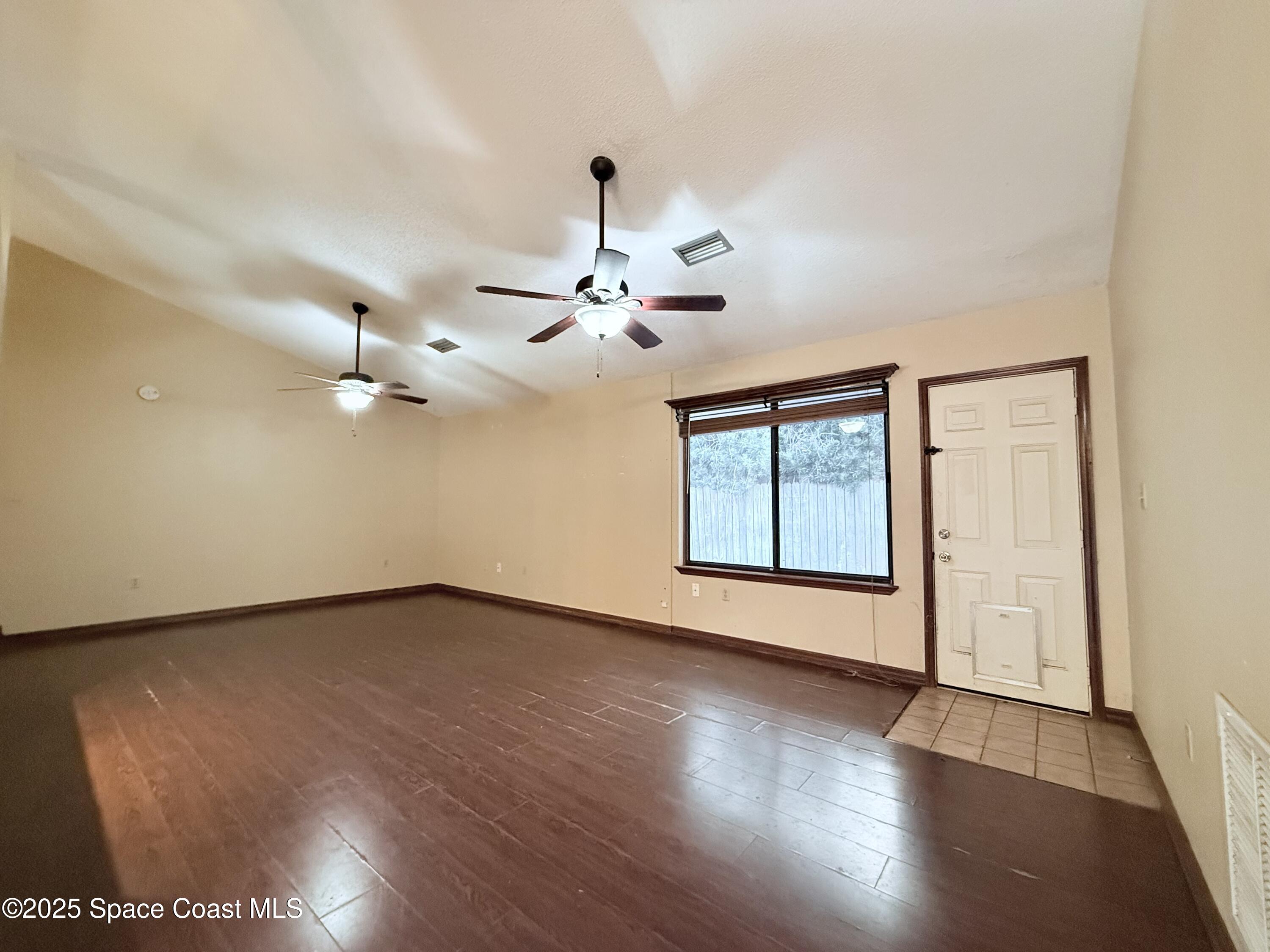 6180 Balboa Street Cocoa, FL 32927 - Photo 6 of 44 a view of an empty room with a window and wooden floor