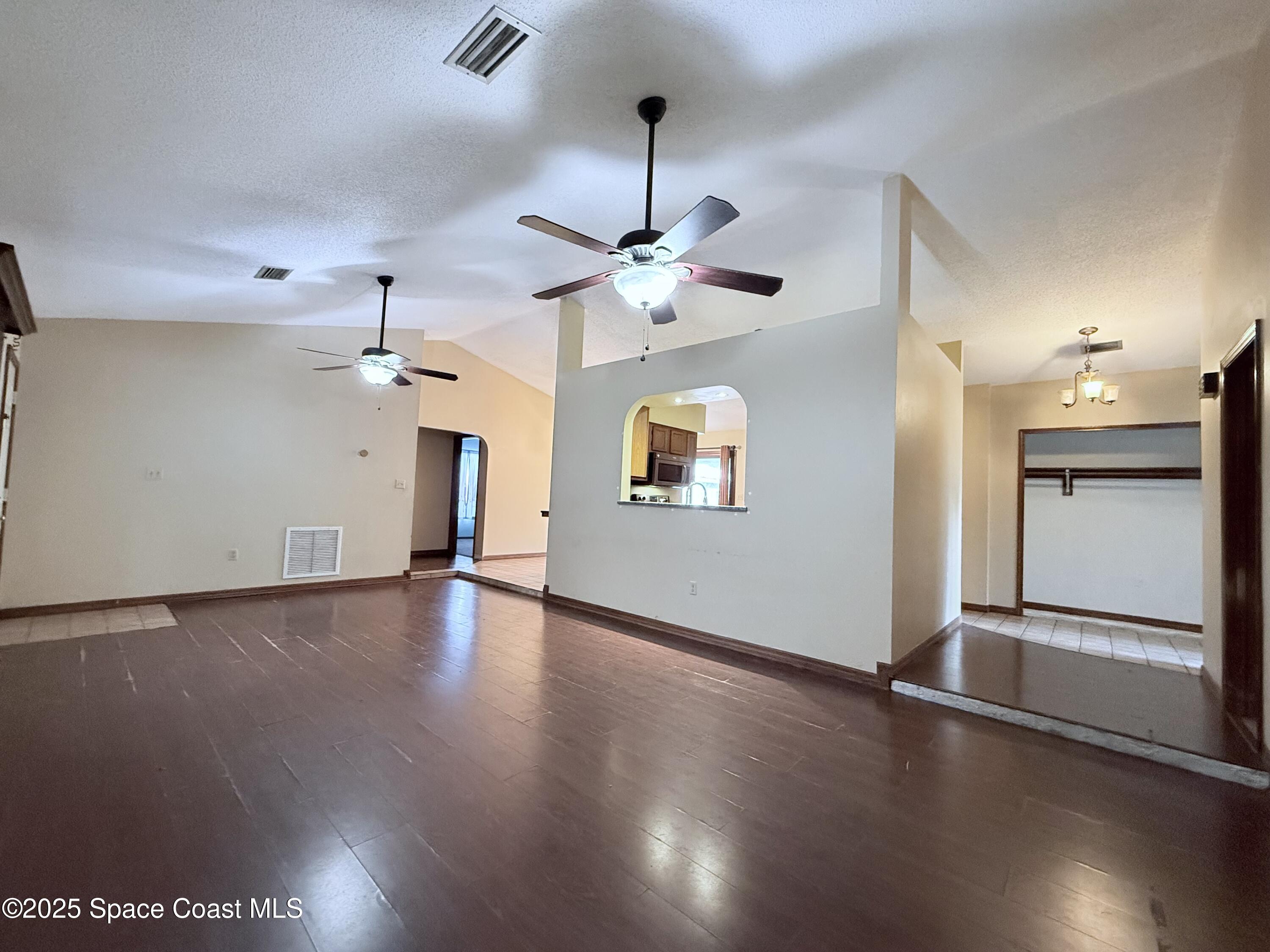 6180 Balboa Street Cocoa, FL 32927 - Photo 9 of 44 a view of an empty room with a kitchen and wooden floor