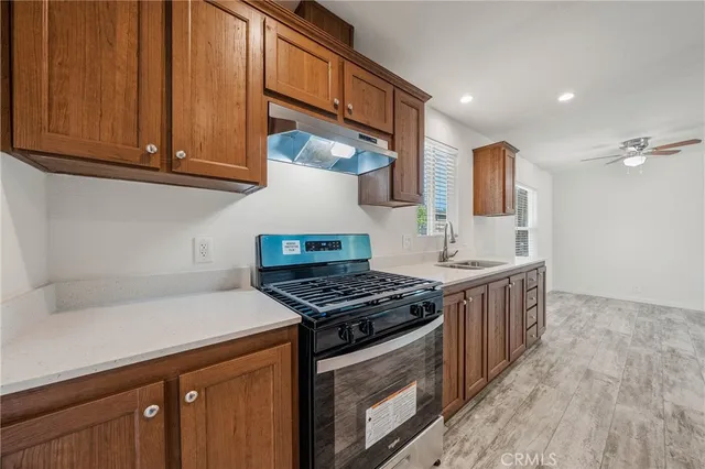 a kitchen with stainless steel appliances granite countertop a stove a sink and a microwave