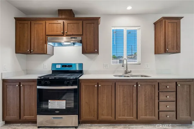 a kitchen with stainless steel appliances granite countertop a stove a sink and a microwave
