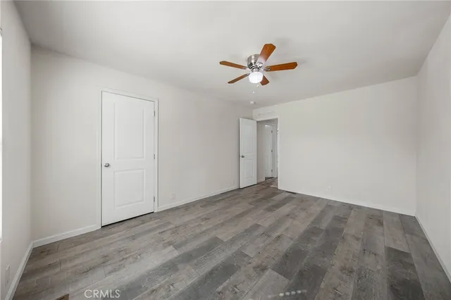 a view of a room with wooden floor and ceiling fan