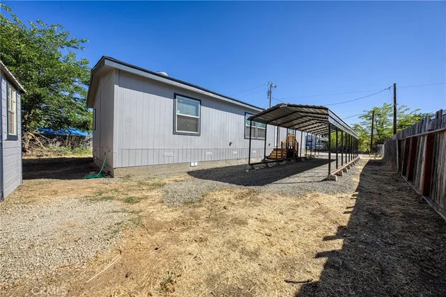 a view of a house with backyard and trees