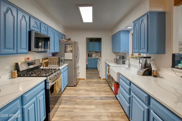 a kitchen with stainless steel appliances granite countertop a stove top oven a sink and dishwasher a oven with wooden cabinets